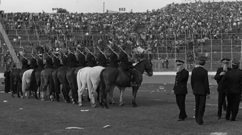 Getty Images Mounted police on the pitch at Hampden after the 1980 Scottish Cup final - they are watching fans on the terraces