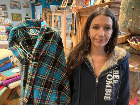 A woman stands next to the new Wiviliscombe tartan