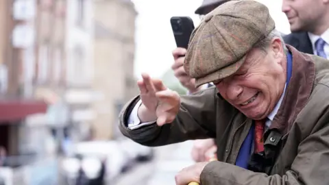 PA Nigel Farage flinches after an object is thrown at him.