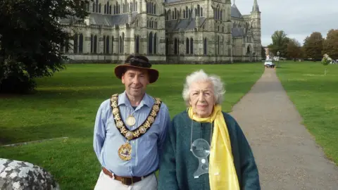 STFH The Mayor of Salisbury with Phyll standing on a pathway in front of Salisbury Cathedral