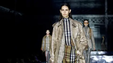 Reuters Models wearing Burberry outfits on a fashion show walkway