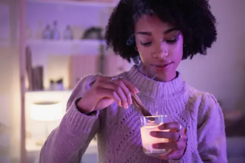 Getty Images Young woman in jumped lights a candle 