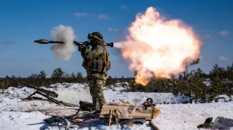 A Ukrainian solider firing an RPG with snow on the ground