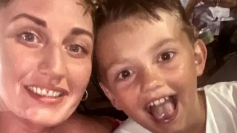 Rebecca Parker Rebecca Parker and her son Christopher McBurnie smile at the camera with their heads together.