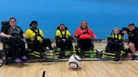 Norwich City powerchair FC squad in their kit lined up with the coaching team