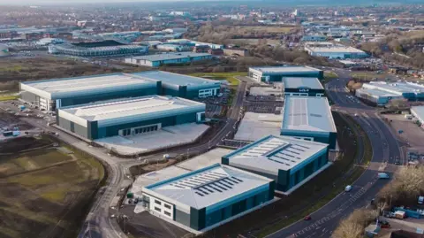 Marketing Derby Aerial shot of eight large modern warehouses on the edge of a city