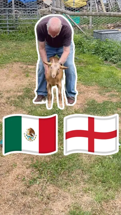 A man in blue holding a Royal Golden Guernsey Goat and a Mexico flag and an England flag