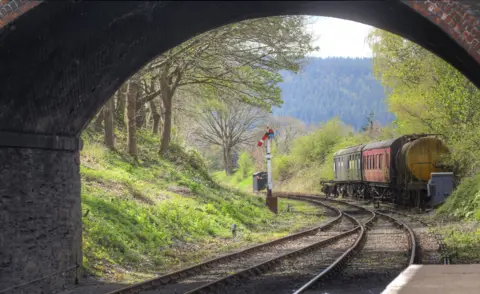 Mike Read Railway carriages seen through the arch of a bridge