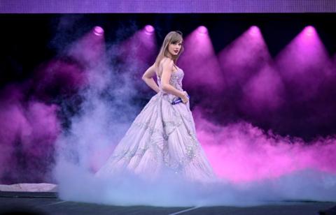 taylor Swift on stage in a purple dress