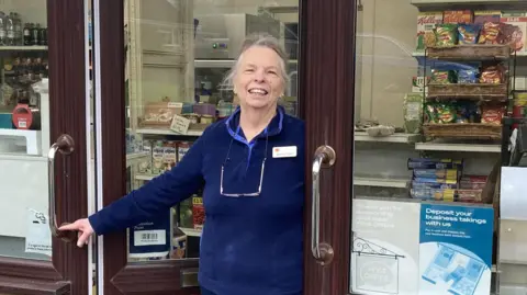 A woman stood in the doorway to a shop