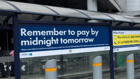 Manchester Airport 'Remember to pay' sign at the airport.