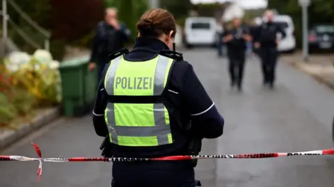 German police officers seal of the area where Herdecke's Mayor Iris Stalzer was found with stab wounds. Photo: 7 October 2025