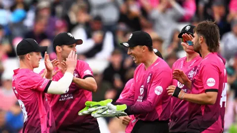 Somerset's Ben Green goes in to celebrate with high fives with his team-mates
