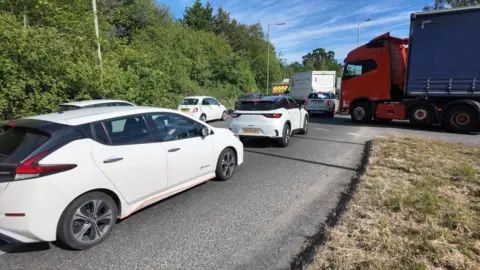 Cars and lorries queue bumper to bumper on one of the city's roundabouts with traffic unable to move.