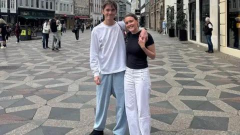 Maisie Roberts Maisie Roberts, who has her hair tied back and is in a black top, with boyfriend Bertie Kinnings, who is in a white T-shirt and has his arms around her.