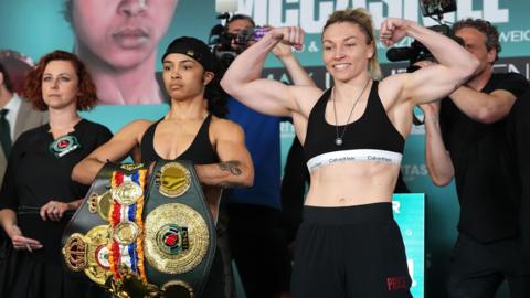 Jessica McCaskill poses with her belts beside a smiling Lauren Price