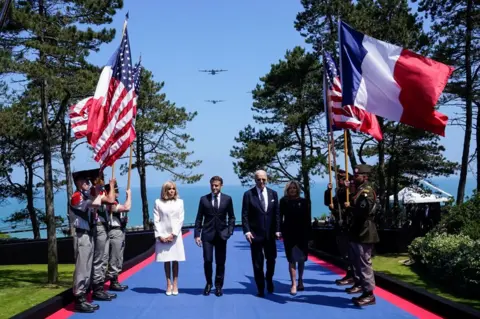 Elizabeth Frantz/REUTERS U.S President Joe Biden, first lady Jill Biden, French President Emmanuel Macron and his wife Brigitte Macron attend a ceremony to mark the 80th anniversary of D-Day at the Normandy American Cemetery and Memorial in Colleville-sur-Mer, France, June 6, 2024. 