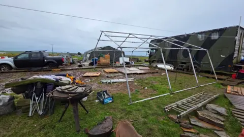 Johnny Rutherford/BBC A general view of the Noon Cregg CIC Veterans Retreat showing tents blown over and belongings strewn all over the ground.
