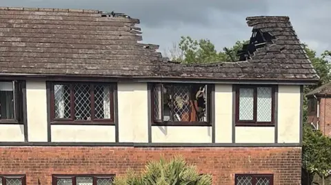 Stuart Dunn A house after it was stuck by lightning. The roof has a large hole in it where the house was hit and caused a fire. The picture shows the house after the fire was put out. 