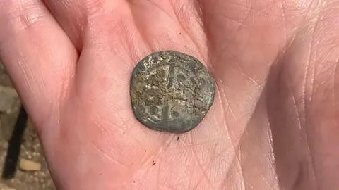 University of Leicester A small coin with a cross in the middle