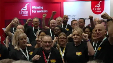 BBC A crowd of Winter Fuel Payments campaigners raise their fists in the air 