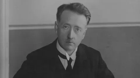 FPG/Getty Images A black and white archive photo of William Thomas Cosgrave. He had short hair and is wearing a black suit, white shirt and a black tie.