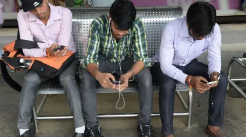 Getty Images Indians surf the internet on their phones at a free wi-fi zone inside a suburban railway station in Mumbai on August 22, 2016. 