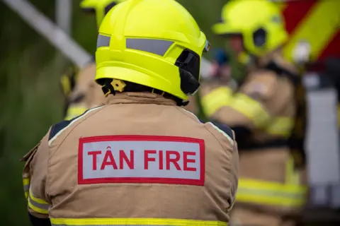 A fireman in a jacket that reads "Tan" and "Fire" 