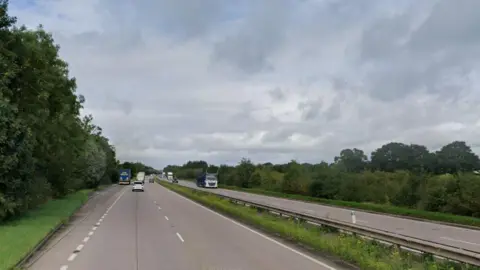 A long stretch of dual carriageway with trees flanking it on either side