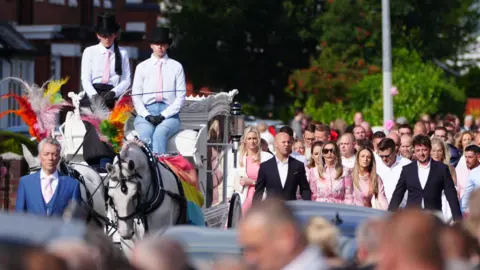 PA Media Relatives walk behind the horse-drawn carriage carrying the coffin of stabbing victim Elsie Dot Stancombe in Southport as the cortege travels to her funeral at St John's Church in Birkdale