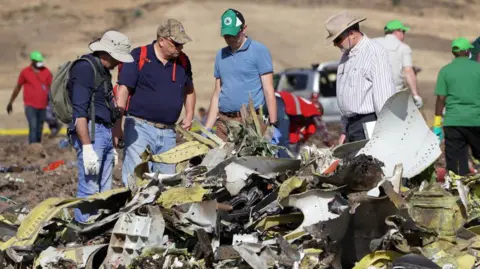 Investigators with the US National Transportation and Safety Board (NTSB) look over debris at the crash site of Ethiopian Airlines Flight ET 302 on 12 March, 2019 in Bishoftu, Ethiopia.