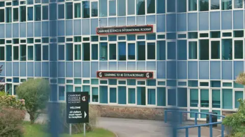 The outside of the Camborne Science and International Academy. It has blue panels alongside many windows.