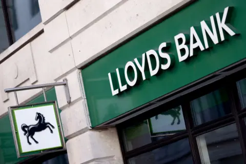 Reuters The outside a of Lloyds Bank branch. It has the companies logo of the black horse and the dark green branding. 