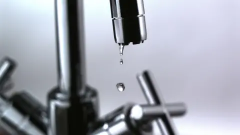 Generic photograph of a silver mixer tap with dripping water