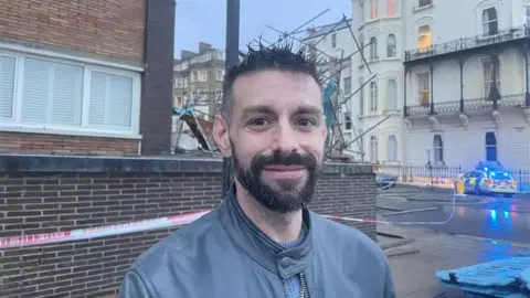 A young man with black spikey hair and a beard. 