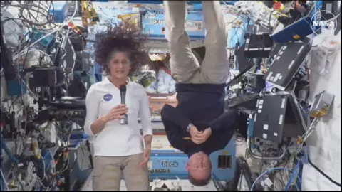 Nasa Butch Wilmore tipped upside down in zero gravity during the press conference while next to Suni Williams