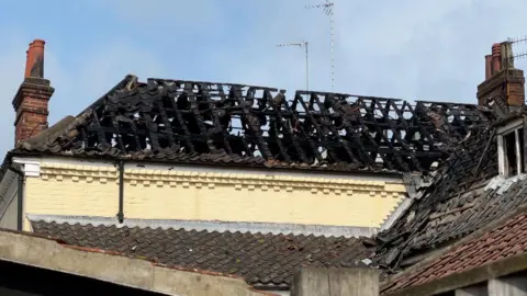 Part of the roof of the former Cat and Fiddle pub. All that remains are smoke-blackened timbers.