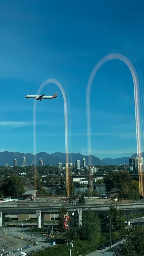 Carrol Brown A aeroplane seems to fly through an arch reflected in a hotel window