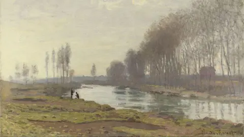 Claude Monet's painting called The Petit Bras of the Seine at Argenteuil (1872). It depicts a green river with marshland and brown bog to the left of the river. There are two black silhouettes crouched and standing by the river. The trees are bare. 