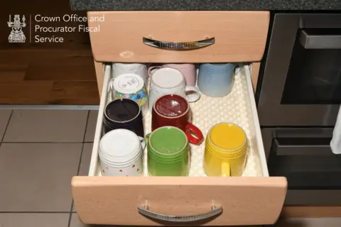 COPFS Le Creuset mugs in a drawer next to the oven. They are all different colours.