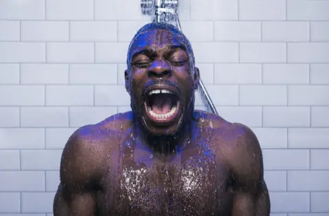 Gloucester rugby player Christian Wade grimaces as he stands under a cold shower
