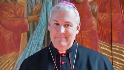 A bishop is smiling towards the camera