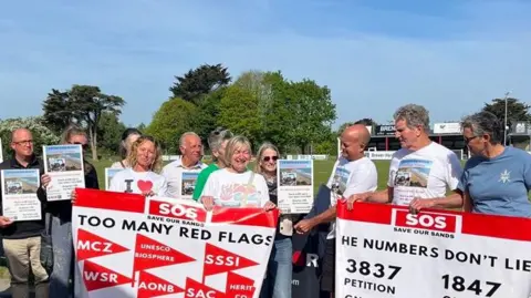 Protesters holding signs outside the planning meeting at Barnstaple Rugby Club