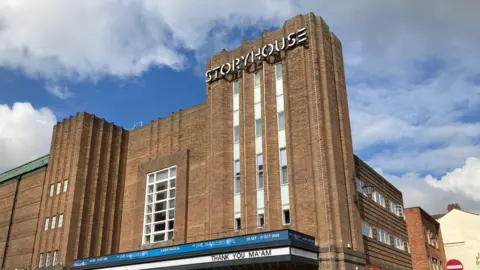 A large brick building which has a sign at the top reading 'Storyhouse'