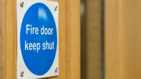 A fire door sign, screwed into a fire door