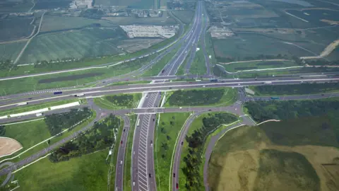 National Highways An aerial view of the layout of a new road junction which includes a flyover and an underpass.
