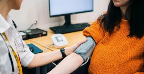 Getty A nurse checking someones blood pressure in a clinical settings. 