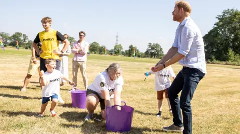 Reuters Prince Harry prepares to be struck by a water bomb thrown by a young boy.