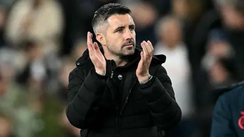 Alan Sheehan applauds after the Manchester City game 