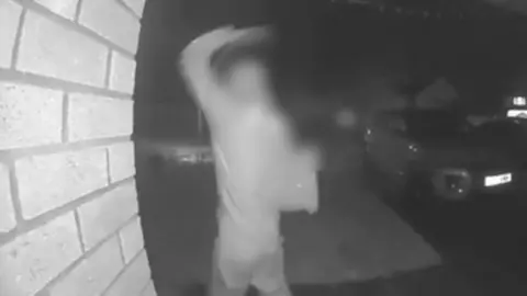 Doorbell footage of a delivery worker throwing a parcel